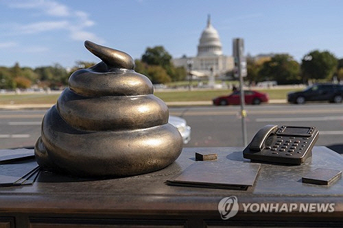 26일(현지시간) 미국 워싱턴DC 연방의회 의사당 건너편에 똥 모형의 황동색 조형물이 설치돼 있다.  [워싱턴 AP=연합뉴스]